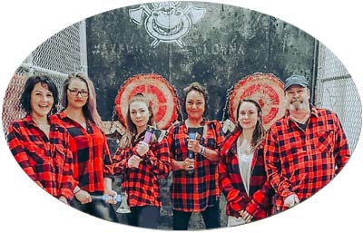 image of a group of individuals getting ready to throw some axes at a target